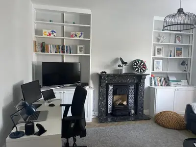 a room with a desk with a computer and a fireplace at Beautiful family home with hot tub in Wivenhoe