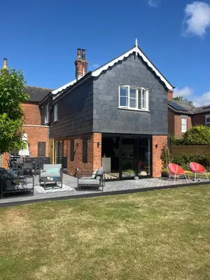 a house with a patio with two chairs at Beautiful family home with hot tub in Wivenhoe