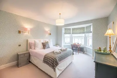 a bedroom with a bed and a table in it at Rosebank, a stunning holiday home in Aldeburgh in Aldeburgh