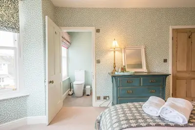 a bedroom with a bed and a blue dresser and a mirror at Rosebank, a stunning holiday home in Aldeburgh in Aldeburgh