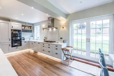 a kitchen with white cabinets and a large window at Rosebank, a stunning holiday home in Aldeburgh in Aldeburgh
