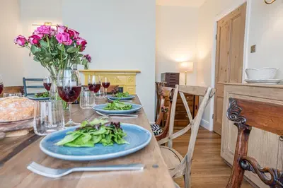 a table with plates of food and glasses of wine at Rosebank, a stunning holiday home in Aldeburgh in Aldeburgh