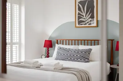 a bedroom with a white bed with two towels on it at Stylish & Chic 3 bed House in Cambourne