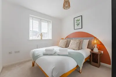 a bedroom with a large bed and a window at Stylish & Chic 3 bed House in Cambourne