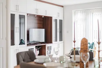 a living room with a table and a tv at Stylish & Chic 3 bed House in Cambourne