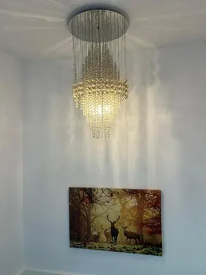 a chandelier hanging from a ceiling with a picture at Luxurious 3 Bedroom Contractor House Stevenage by Randz Property Group - Short Lets l Sleeps 6 l Free Parking & Wifi in Stevenage