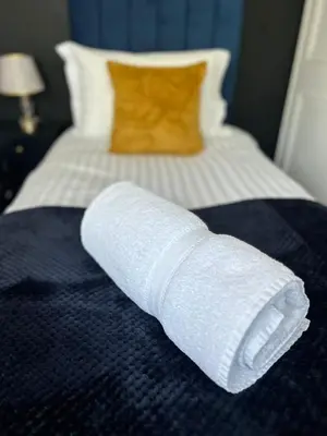 a roll of toilet paper sitting on a bed at Luxurious 3 Bedroom Contractor House Stevenage by Randz Property Group - Short Lets l Sleeps 6 l Free Parking & Wifi in Stevenage