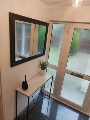 a room with two windows and a table with a plant on it at Luxurious 3 Bedroom Contractor House Stevenage by Randz Property Group - Short Lets l Sleeps 6 l Free Parking & Wifi in Stevenage