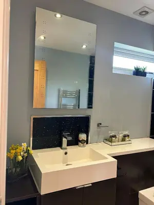 a bathroom with a white sink and a mirror at Luxurious 3 Bedroom Contractor House Stevenage by Randz Property Group - Short Lets l Sleeps 6 l Free Parking & Wifi in Stevenage