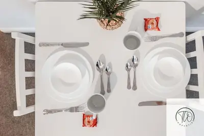 a white table with plates and utensils on it at Jardine House in Colchester