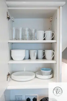 a cupboard filled with plates and bowls and dishes at Jardine House in Colchester