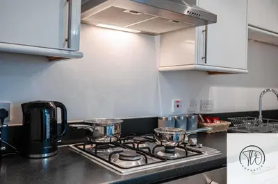 a kitchen with a stove with pots and pans on it at Jardine House in Colchester