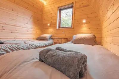 a bedroom with two beds in a wooden cabin at The Bell Inn in Wendens Ambo
