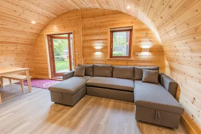 a living room with a couch in a wooden cabin at The Bell Inn in Wendens Ambo