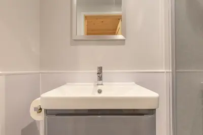 a bathroom with a white sink and a mirror at The Bell Inn in Wendens Ambo