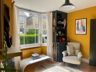 a living room with a chair and a window at Beautiful Victorian House in Central Chelmsford in Chelmsford