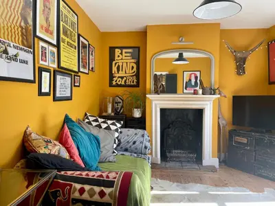 a living room with a couch and a fireplace at Beautiful Victorian House in Central Chelmsford in Chelmsford