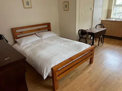 a bedroom with a bed and a desk and a table at 7a Sir Alf Ramsey Way in Ipswich