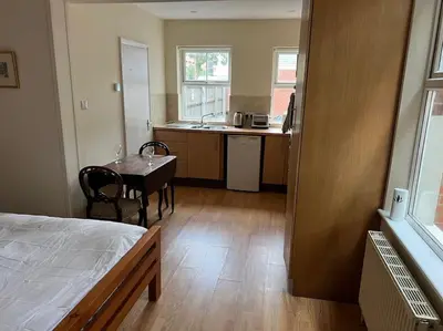a room with a bed and a table and a kitchen at 7a Sir Alf Ramsey Way in Ipswich