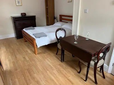 a bedroom with a bed and a table with two chairs at 7a Sir Alf Ramsey Way in Ipswich