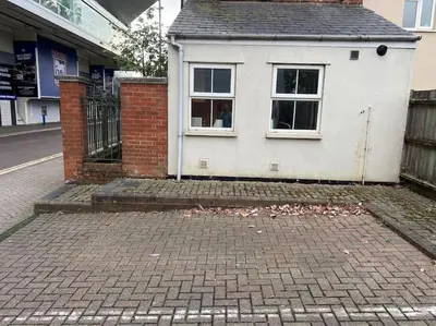 a white house with a window on a brick street at 7a Sir Alf Ramsey Way in Ipswich