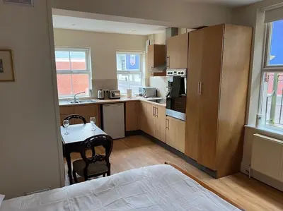 a kitchen with a table and a bed in a room at 7a Sir Alf Ramsey Way in Ipswich