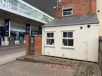 a small white house in front of a building at 7a Sir Alf Ramsey Way in Ipswich