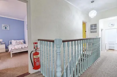 a room with a staircase with a fire extinguisher at Walton Beach Holiday Lets in Walton-on-the-Naze