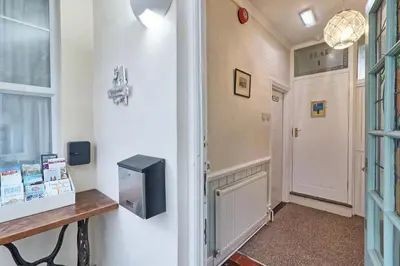 a hallway with a door and a television on a wall at Walton Beach Holiday Lets in Walton-on-the-Naze