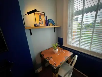 a table with a potted plant on it next to a window at Stylish and artistic flat in Southend on Sea - 2 Double Bedrooms, Free on-street parking in Southend-on-Sea