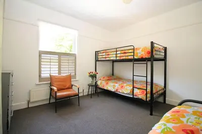 a bedroom with two bunk beds and a chair at Cottage in Walton on the Naze in Walton-on-the-Naze