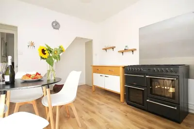 a kitchen with a black stove and a table at Cottage in Walton on the Naze in Walton-on-the-Naze