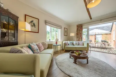 a living room with a couch and a table at Rural bolthole in Constable country estate - The Woodshed in Higham