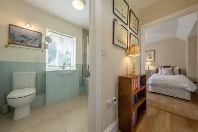 a bathroom with a bed and a toilet and a sink at Rural bolthole in Constable country estate - The Woodshed in Higham