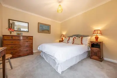 a bedroom with a large white bed and a dresser at Rural bolthole in Constable country estate - The Woodshed in Higham
