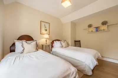 two beds in a room with white sheets at Rural bolthole in Constable country estate - The Woodshed in Higham