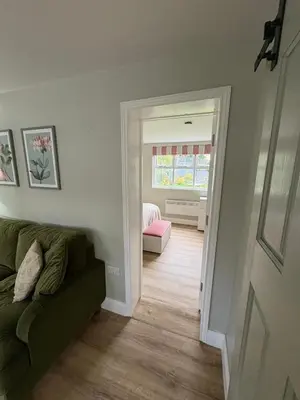 a living room with a green couch and a window at Little Pear Tree in Stock