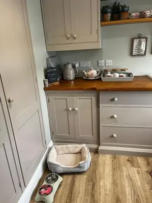 a kitchen with a dog bed sitting on the floor at Little Pear Tree in Stock
