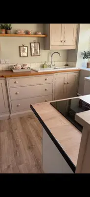 a kitchen with white cabinets and a sink and a counter at Little Pear Tree in Stock
