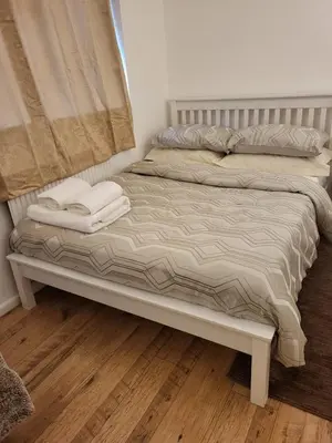 a bed with two towels on top of it at Homely Space in Havering, Essex in Havering atte Bower