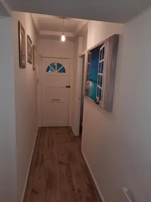 a hallway with a white door and a wooden floor at Homely Space in Havering, Essex in Havering atte Bower