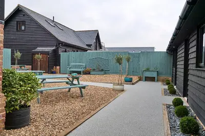 a backyard with a picnic table and a fence at The Stables Kersey Mill in Whatfield