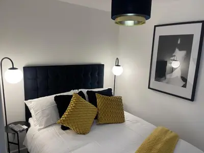 a bedroom with a bed with a black headboard and pillows at Modern-luxury 1bedroom-EnsuiteBathroom-Garden-Wifi in Basildon