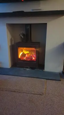 a fireplace in a wall with a fire in it at Beach Walk Cottage in Walton-on-the-Naze