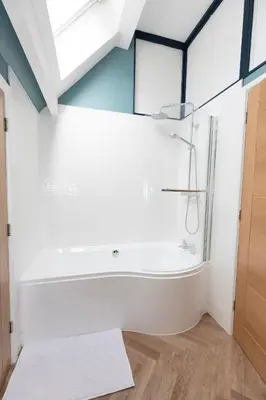 a bathroom with a tub and a glass shower at Central Medieval Grid Unique home with Gated parking in Bury Saint Edmunds