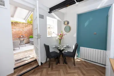 a dining room with a blue door and a table and chairs at Central Medieval Grid Unique home with Gated parking in Bury Saint Edmunds