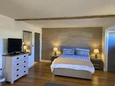 a bedroom with a bed and a flat screen tv at Red lion little barn in Ipswich