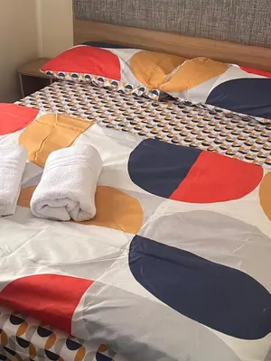 a bed with a multicolored quilt on it at 3 Bed Caravan Sleeps 8 - Parking Bbq Pool in Clacton-on-Sea