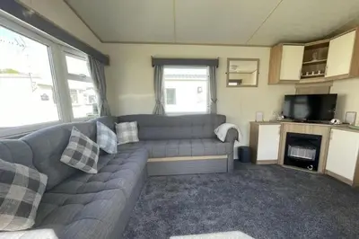 a living room with a couch and a tv at 3 Bed Caravan Sleeps 8 - Parking Bbq Pool in Clacton-on-Sea