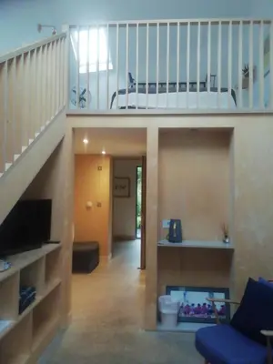 a living room with a staircase and a couch at Five Acre Barn in Leiston
